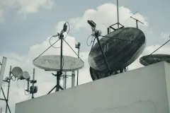 Термінал Starlink на тринозі на тлі українського поля.
