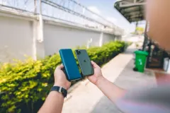 Новий зовнішній акумулятор Belkin в алюмінієвому корпусі поруч з iPhone.